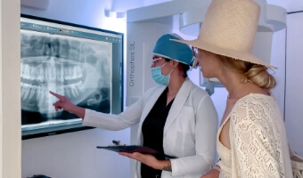 Dentist in Cabo San Lucas explaining the 3-On-6 dental implants treatment to a young female patient