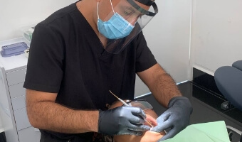 Dentist in Los Cabos placing 3-on-6 dental implants to a middle age man