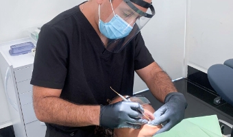 Dr Thomas Koty performing dental implant surgery on a patient