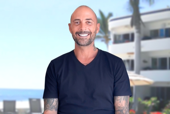 bald young man smiling after getting general dentistry in Los Cabos, Mexico